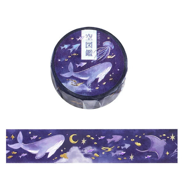 Decorative washi tape with whale design on a purple background