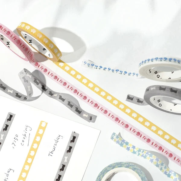 Decorative washi tape rolls with various designs on a white background