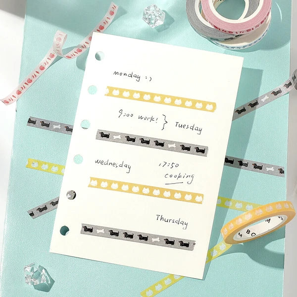 Weekly planner with hand-written notes on a light blue background with decorative tapes.