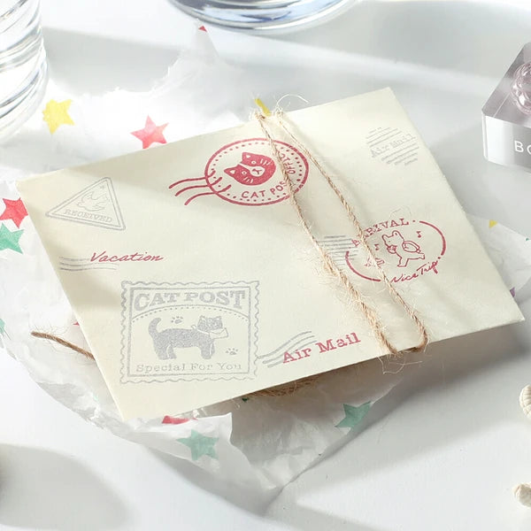 Gift box with decorative stamps and a necklace on a white surface