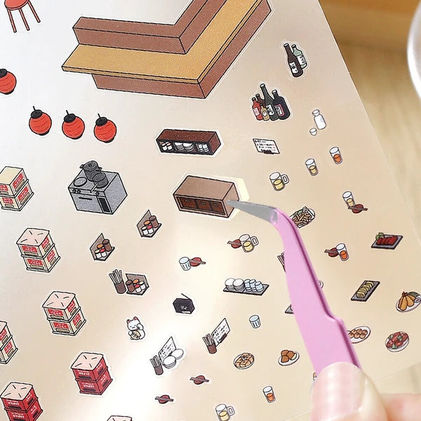 Sticker sheet with various small illustrations and a pink cutting tool on a beige background.