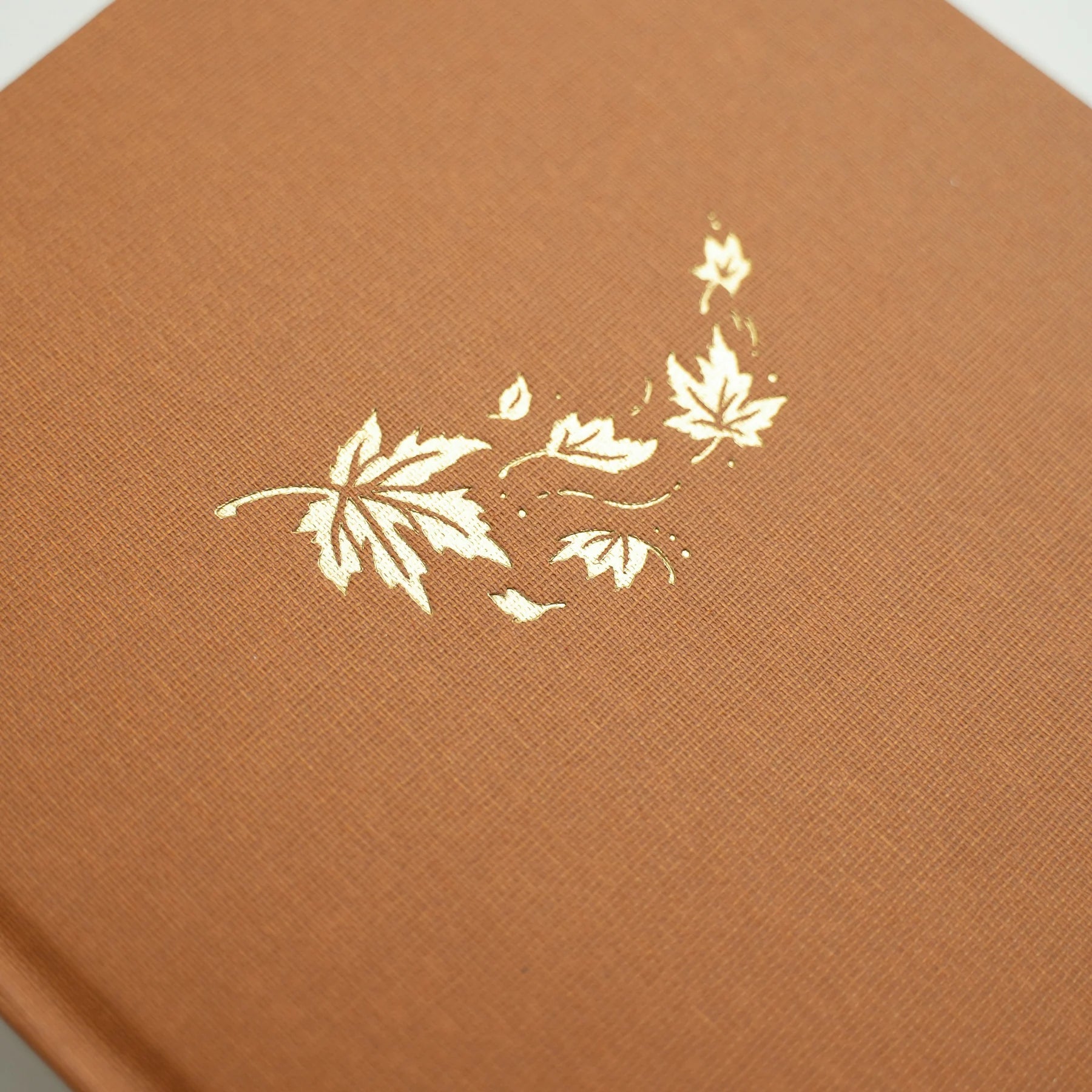 Archer & Olive Swirling Leaves Dotted Notebook closeup on the cover with golden foil falling leaves design - Paper Kooka Stationery Australia