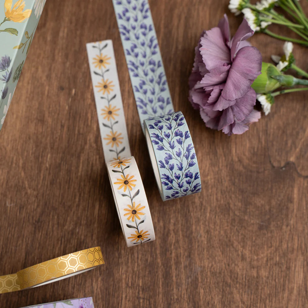 Decorative tapes with floral patterns on a wooden surface with flowers. June Quarterly Box Beekeeper’s Garden from Archer & Olive.